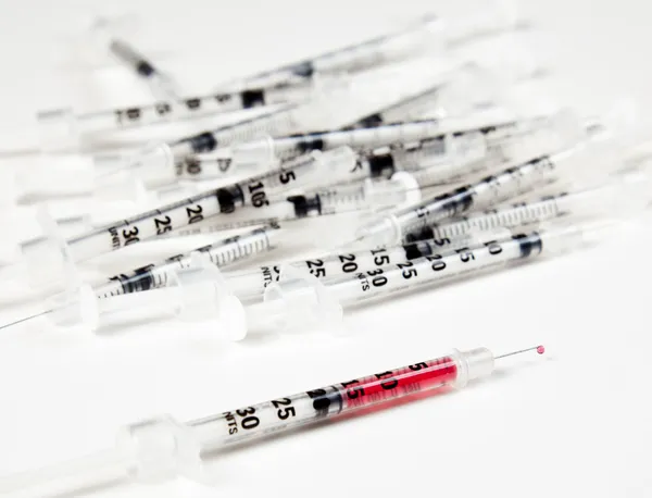 Pile of used syringes with a single one — Stock Photo, Image