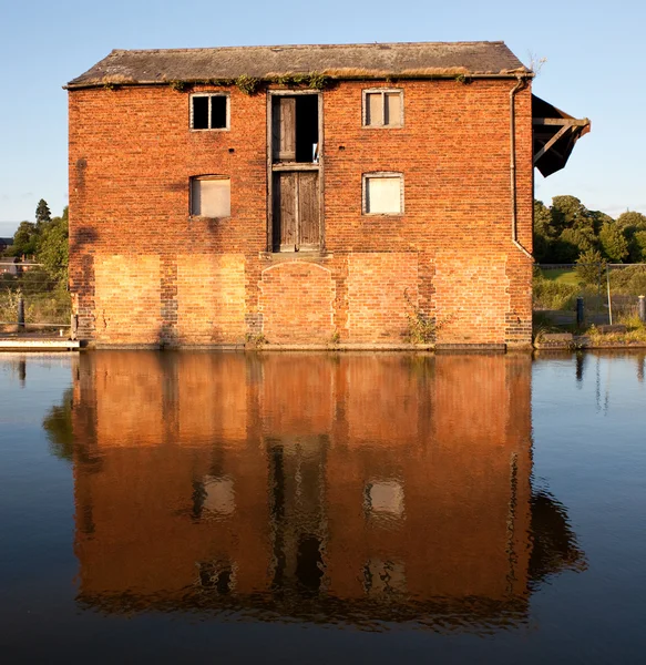 Reflection of red brick warehouse in Ell — Stock Photo, Image