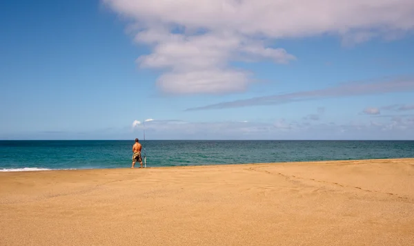 Морской рыбак на пустом пляже — стоковое фото