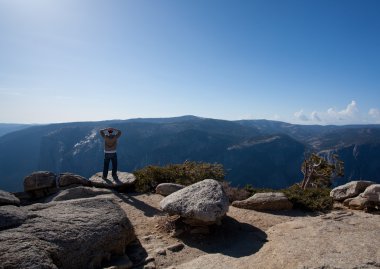 Male hiker looking at view from Yosemite clipart