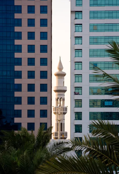 Minarete espiando entre edificios de oficinas — Foto de Stock