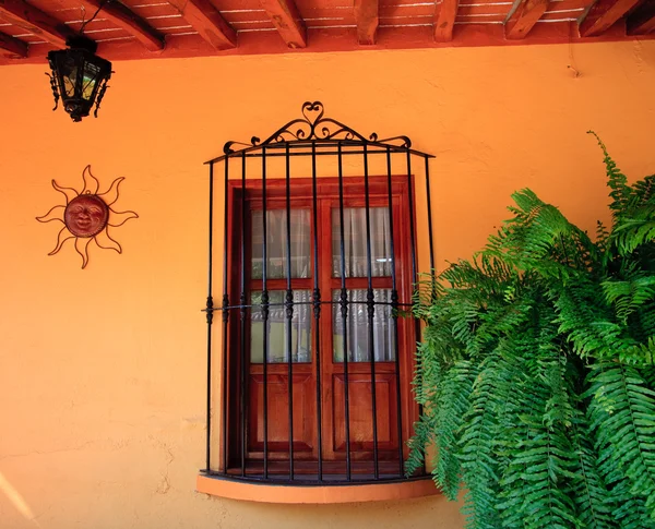 Oranje muur met houten raam — Stockfoto