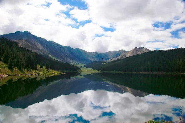 Lago solitario reflejando montañas — Foto de Stock