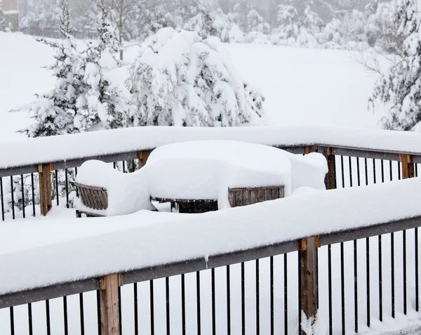 Глубокий снег на палубе со столом — стоковое фото