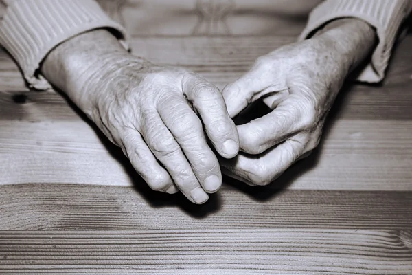 Las manos del anciano en una mesa — Foto de Stock