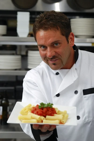 Lachende chef-kok met bord pasta — Stockfoto