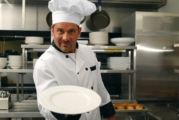 Usmívající se kuchař s prázdným talířem — Stock fotografie