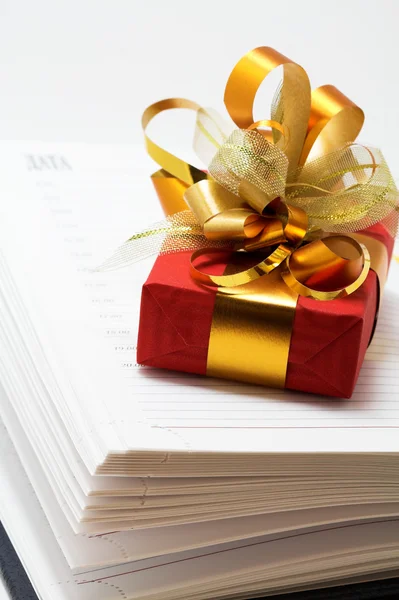 Notizbuch und rotes Geschenk — Stockfoto