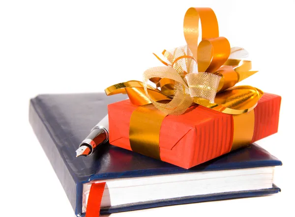 Red gift and notebook with pen — Stock Photo, Image