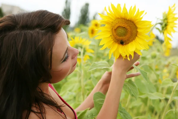 Die junge Frau mit Sonnenblumen. — Stockfoto