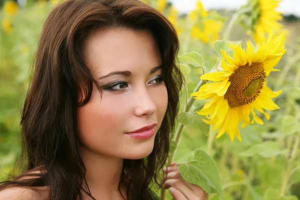 Den unga kvinnan med solrosor. — Stockfoto