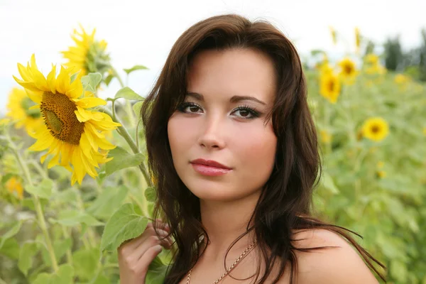 Die junge Frau mit Sonnenblumen. — Stockfoto