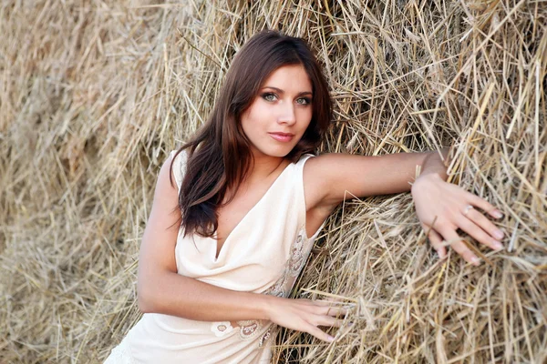 Pretty girl near haystack — Stock Photo, Image