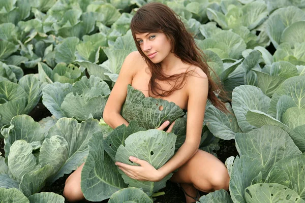 Молода жінка в рослині з капусти — стокове фото