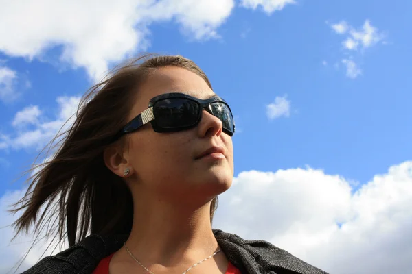 A menina agradável contra o céu azul — Fotografia de Stock
