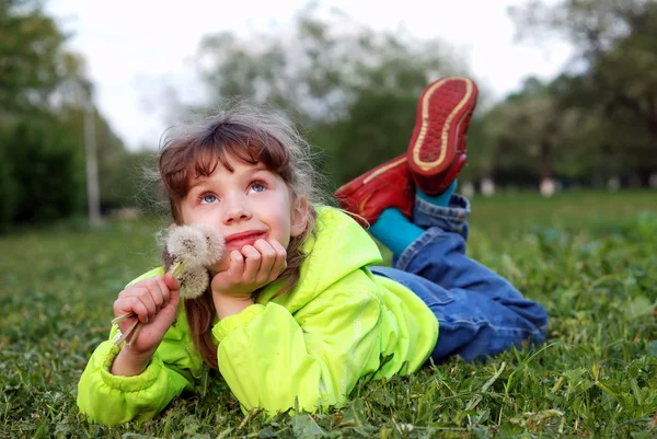 Маленька дівчинка лежить на траві — стокове фото