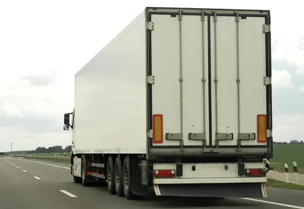 Achterkant van witte vrachtwagen op de snelweg — Stockfoto