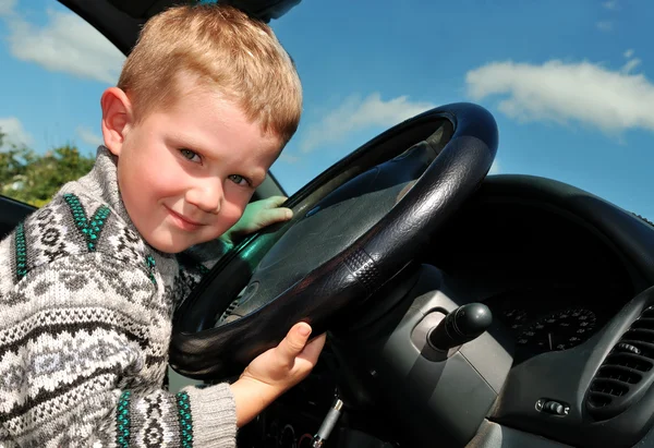 Joyful little boy at driver position in — Stock Photo, Image
