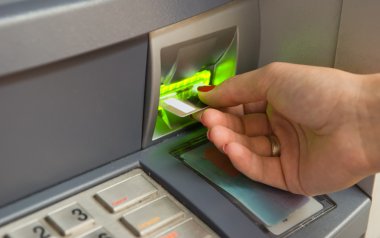 Inserting plastic card visa into ATM clipart