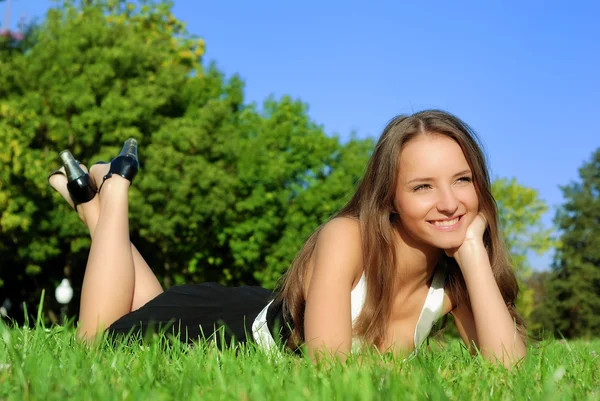 Menina relaxante ao ar livre deitado no gras — Fotografia de Stock