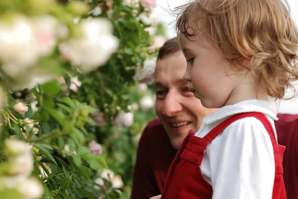 Маленькая девочка, ее отец и цветы — стоковое фото