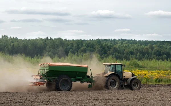 Tractor fertilizing field — Stock Photo, Image