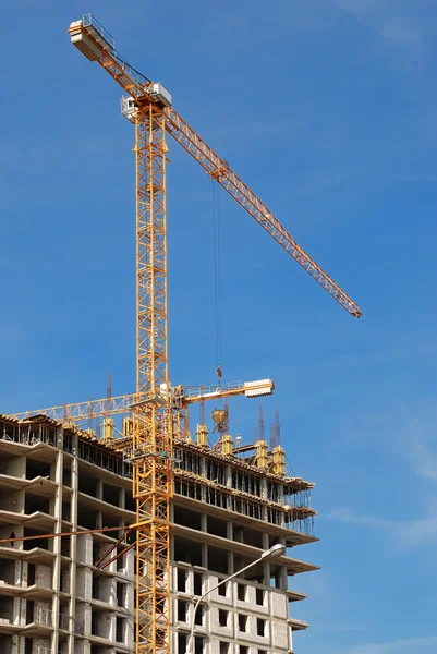 Gelber Turmdrehkran baut ein mehrstöckiges Gebäude — Stockfoto