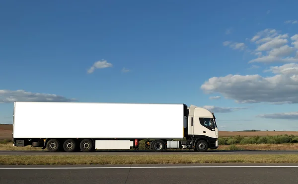 Lange witte vrachtwagen op de snelweg — Stockfoto