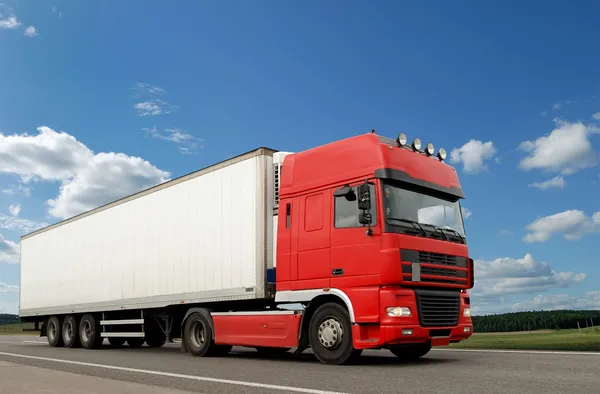 Rode vrachtwagen met witte aanhangwagen over blauwe s — Stockfoto