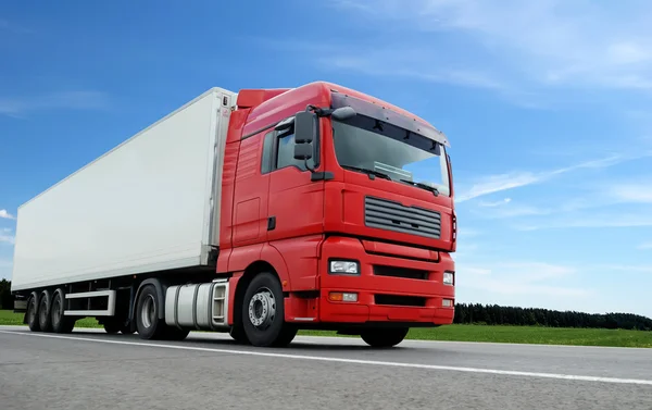 Red lorry with white trailer over blue s — Stock Photo, Image