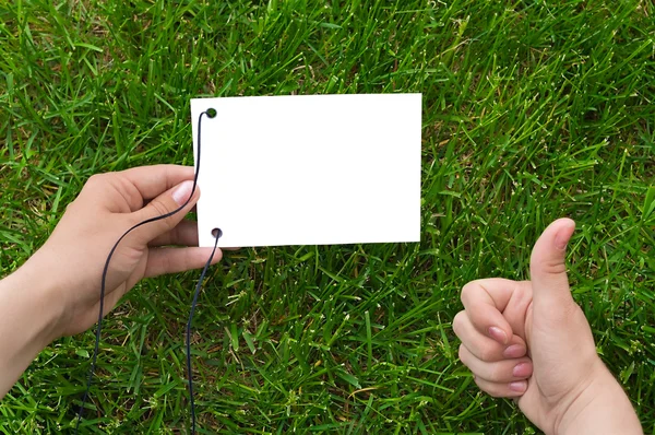 Hands and paper on grass — Stock Photo, Image