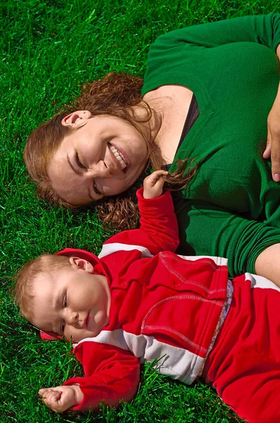 Žena a její dítě na zelené trávě — Stock fotografie
