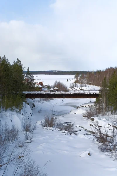 Naturhütte am Flussufer und Bachüberquerung. Winter im Wald. — Stockfoto