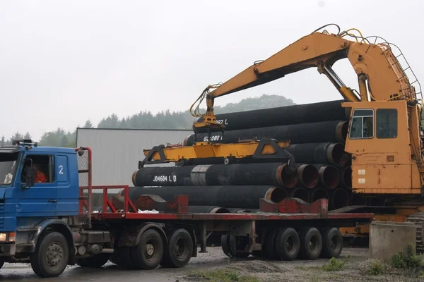 Crane loading pipes in the semi-truck — Stock Photo, Image