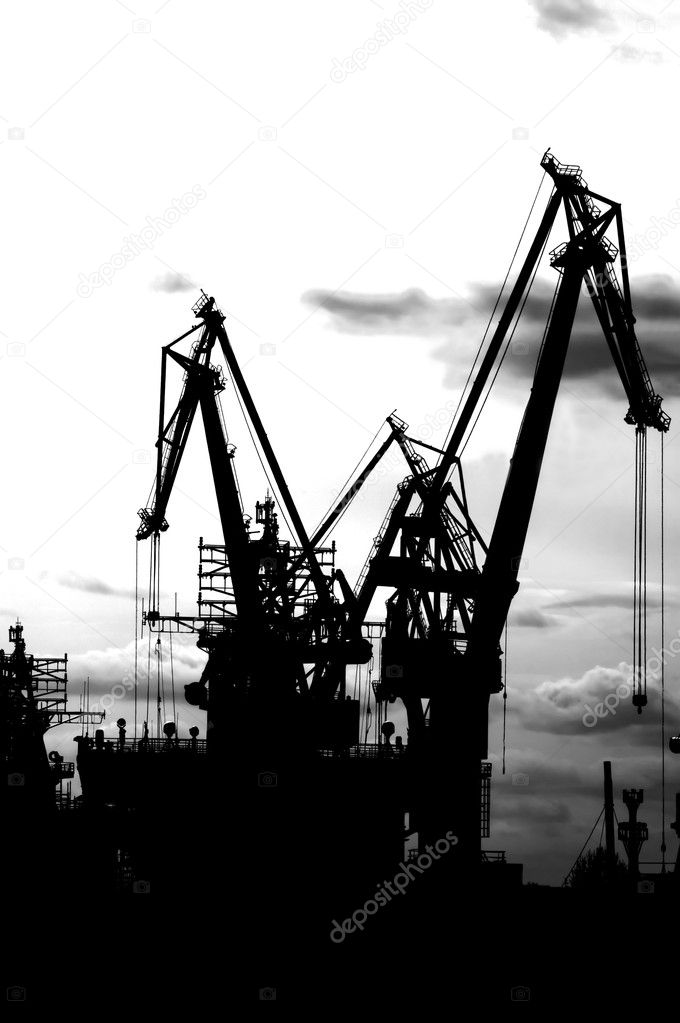 Black silhouette of harbour cranes on th