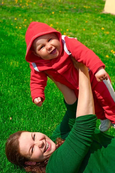 Жінка і її дитина на зеленій траві — стокове фото