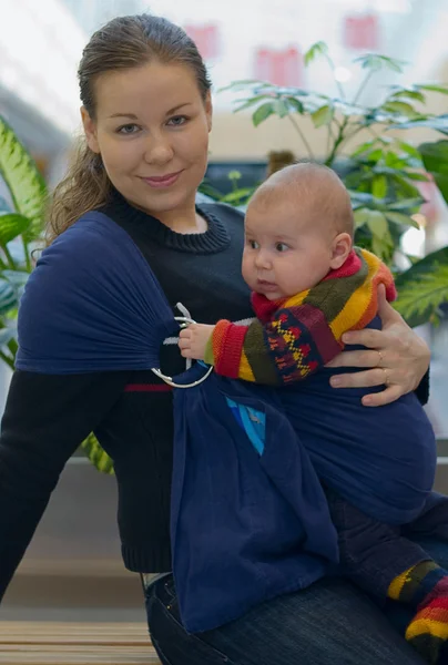 Vrouw houdt haar baby in ring sling — Stockfoto
