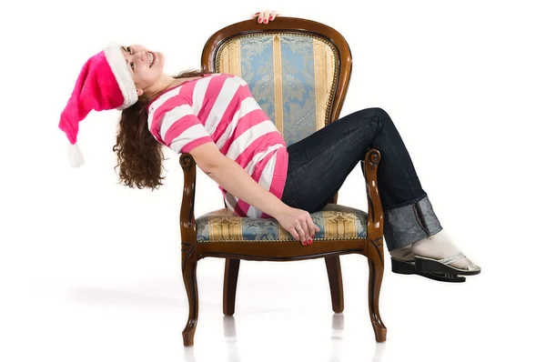Mujer joven yace en silla en el sombrero de Santa Claus — Foto de Stock