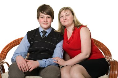Young mother and teenage son on sofa clipart