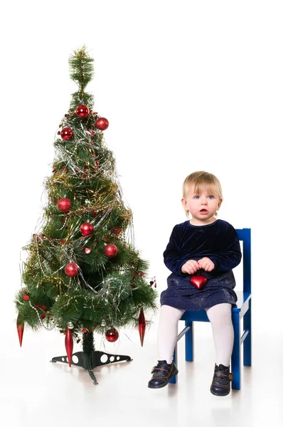 Klein meisje bij de kerstboom — Stockfoto