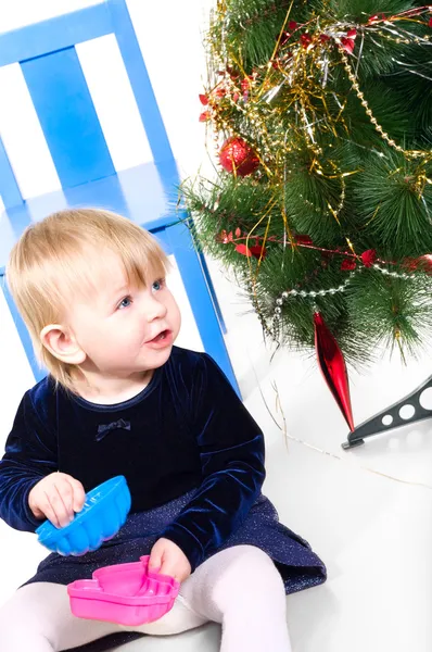 Niña jugando cerca del árbol de Navidad —  Fotos de Stock