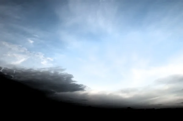 Зловещие облака на голубом небе — стоковое фото