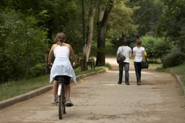 Young woman riding in the park clipart