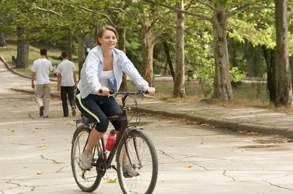 Young woman riding in the park — Stock Photo, Image