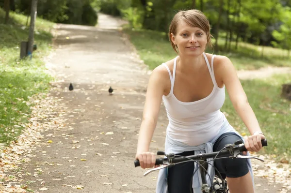 Молода жіноча їзда усміхнений велосипед — стокове фото