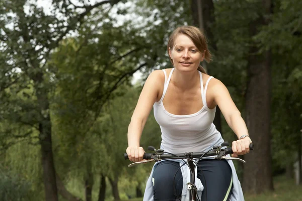 Jovem mulher andando de bicicleta sorridente — Fotografia de Stock