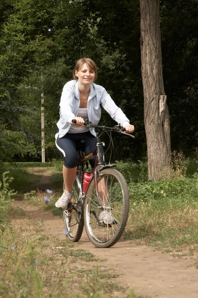 Gülümseyen genç kadın binicilik bisiklet — Stok fotoğraf