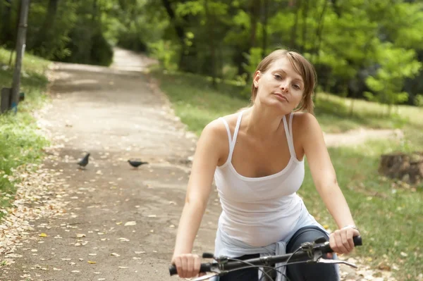 Молода жіноча їзда усміхнений велосипед — стокове фото
