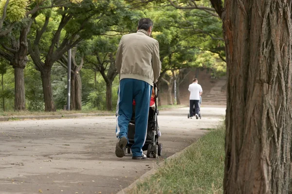 Πατέρες περπάτημα με μια μεταφορά — Φωτογραφία Αρχείου