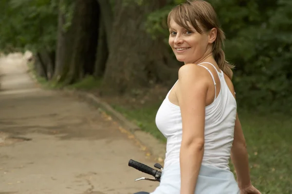 Junge Frau auf lächelndem Fahrrad — Stockfoto
